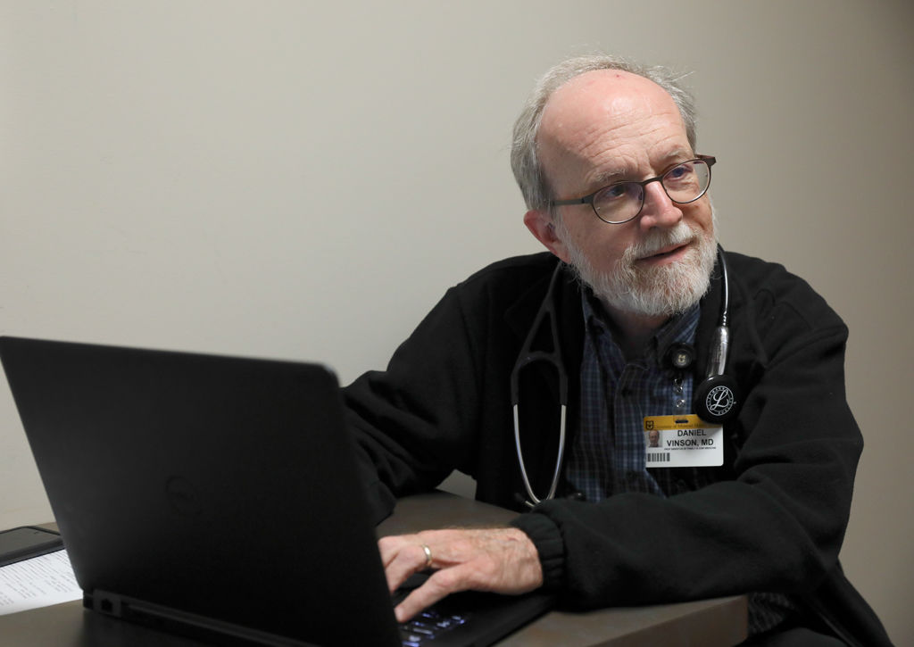 Dr. Daniel Vinson listens to a patient describing her needs at the Phoenix Health Programs clinic